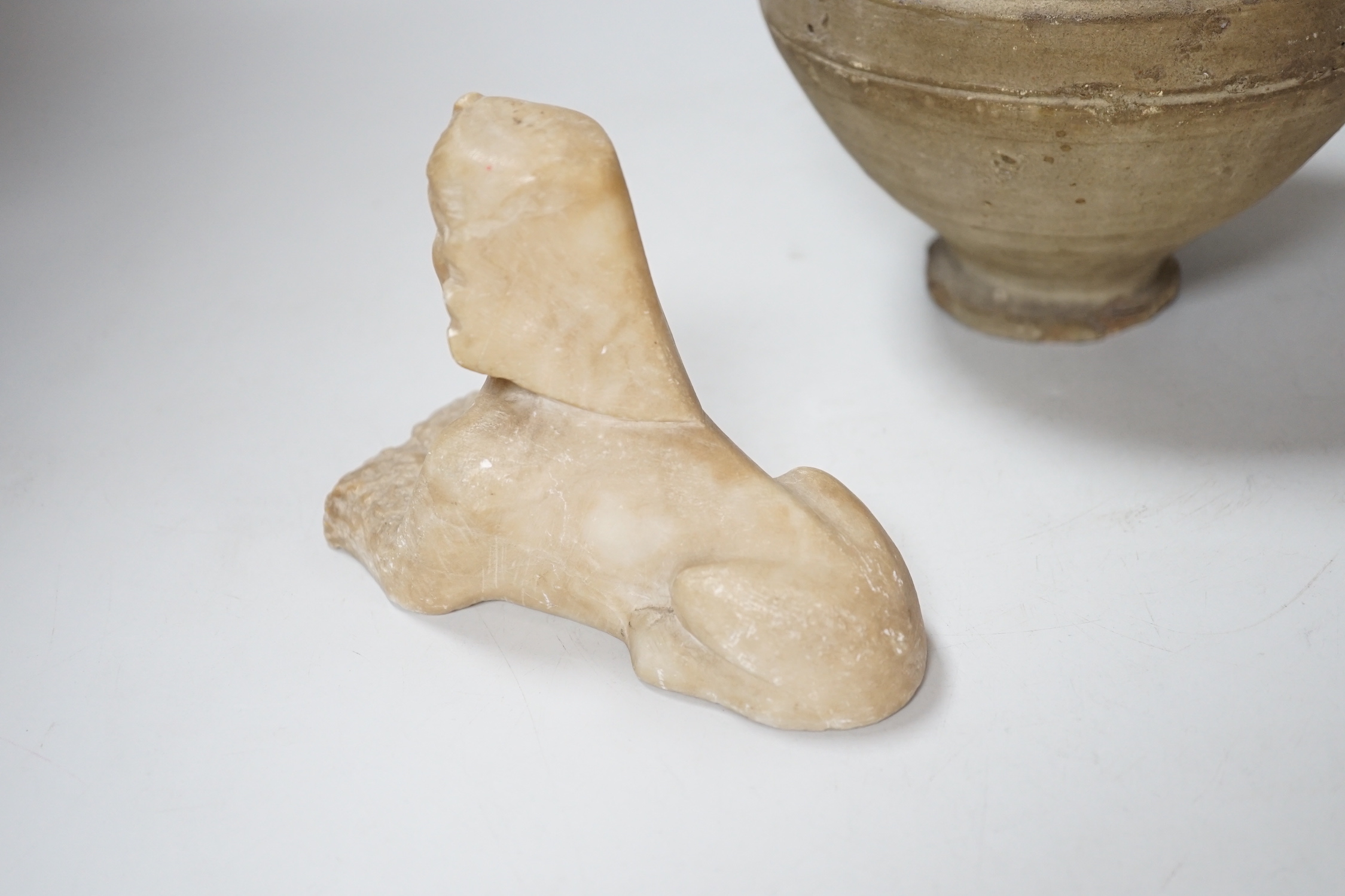 An Egyptian style alabaster model of a sphinx and a twin handled pottery vase, the largest 25cm high